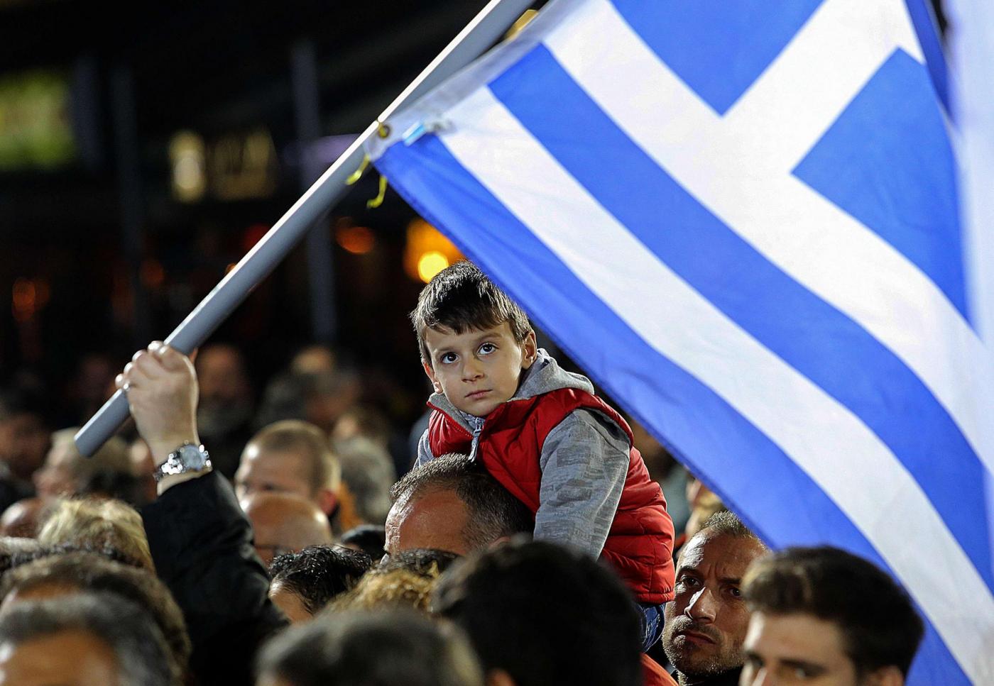 A child sitting on his father's shoulders attends a campaign rally by opposition leader and head of radical leftist Syriza party Alexis Tsipras in Heraklion, on the island of Crete